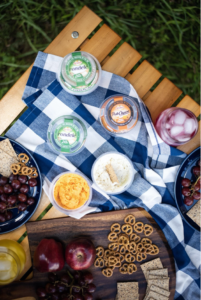 Rondele cheese at a picnic with fruit and pretzels